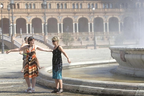 Dos turistas se refrescan en Sevilla