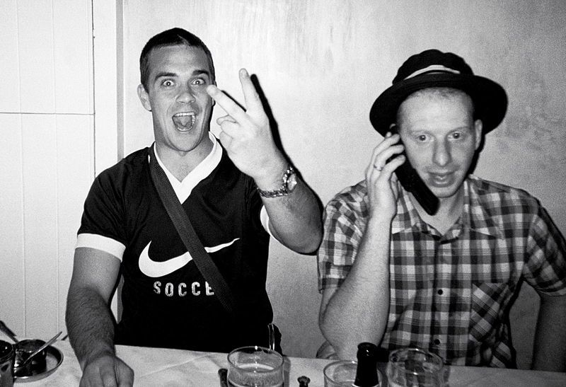 Robbie Williams hace una uve ofensiva a un fotógrafo (Foto: Wikimedia Commons)