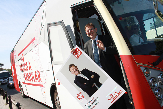 Ximo Puig en su autobús de campaña sosteniendo uno de sus carteles electorales.
